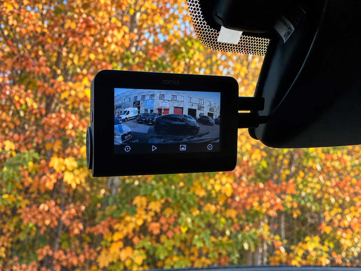 70mai dash cam mounted behind the rear-view mirror with autumn trees outside, fitted by Radio King Dublin