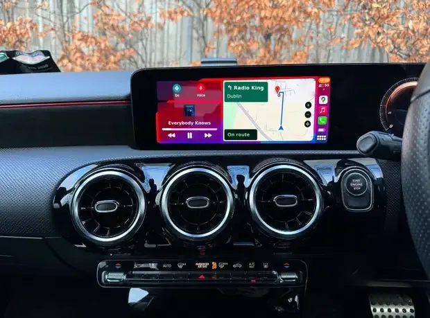 Apple CarPlay on a Mercedes factory screen with Google Maps navigation to Radio King and music playing side by side
