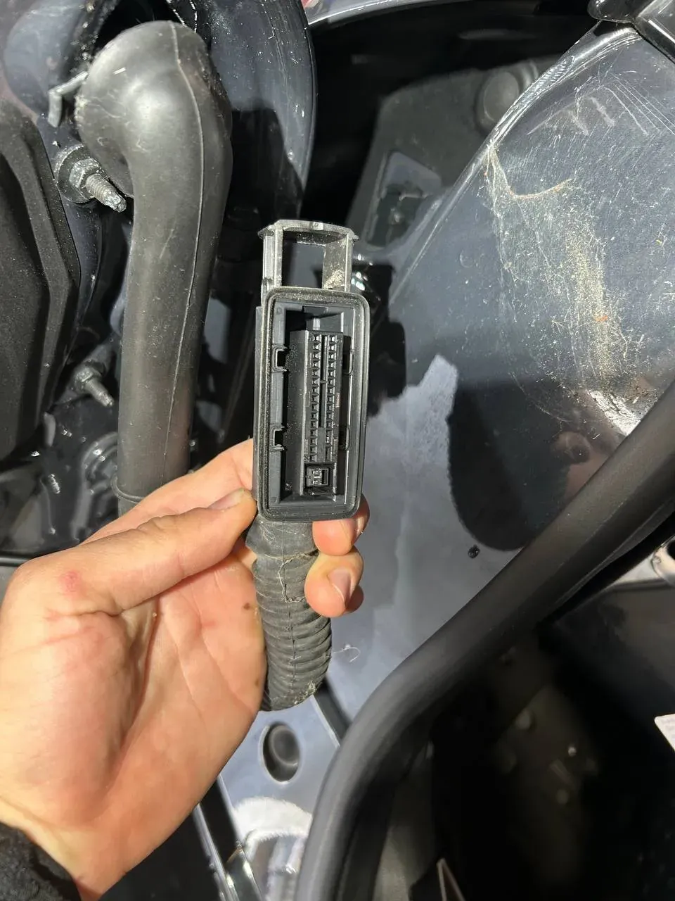 Hardwire kit with fuse taps held next to the fuse box of a Mini Clubman during a dash cam installation in Dublin
