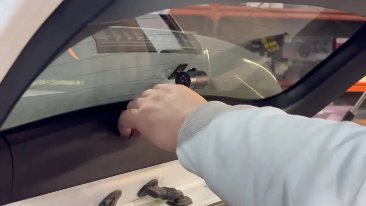 Radio King installer fitting a dash cam behind the windscreen in the Dublin workshop